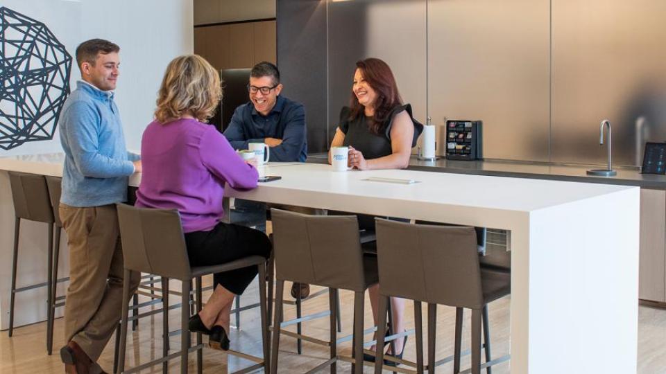 A group of coworkers talking around a lunch table.